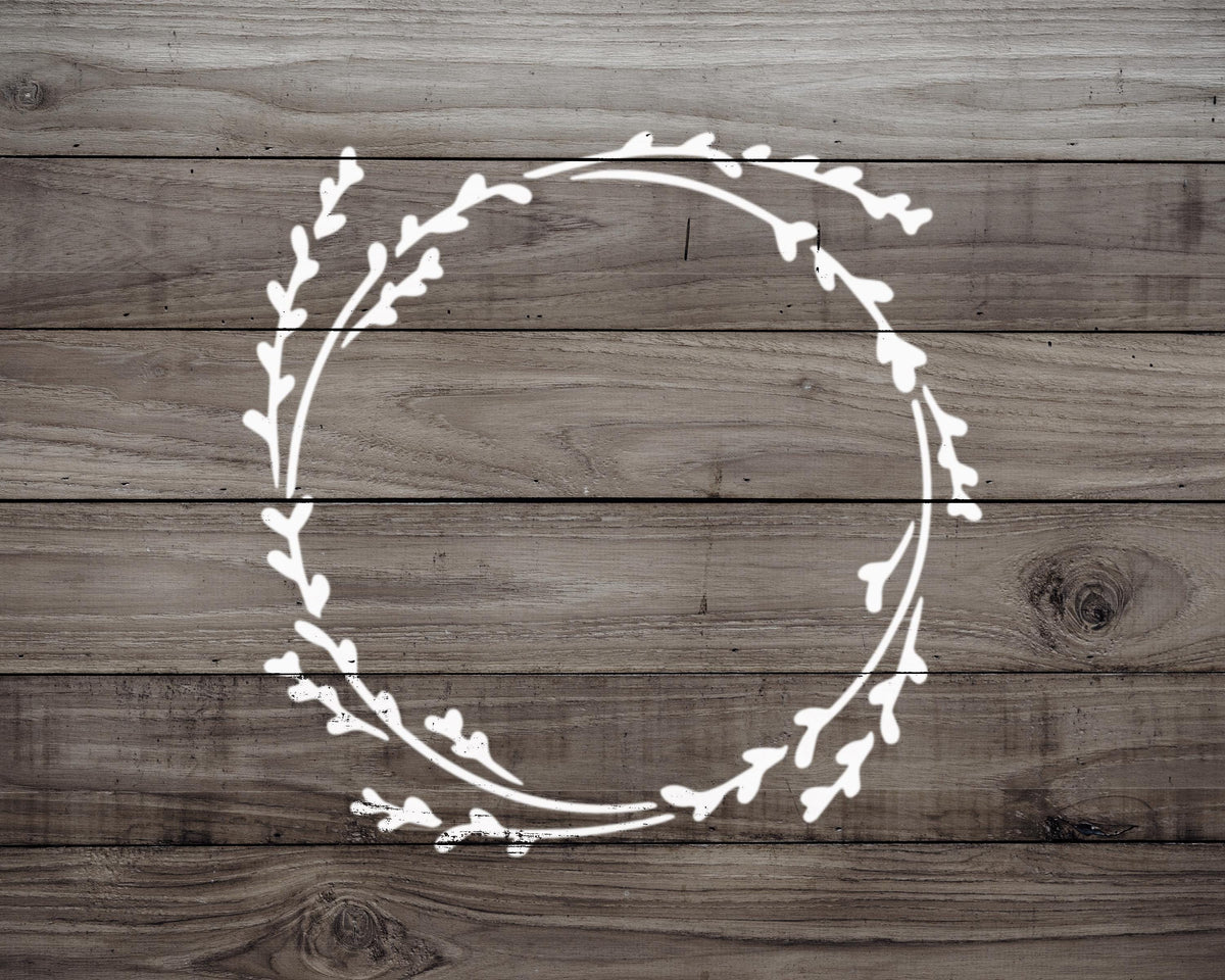 A wreath-like design in white against a wooden background.