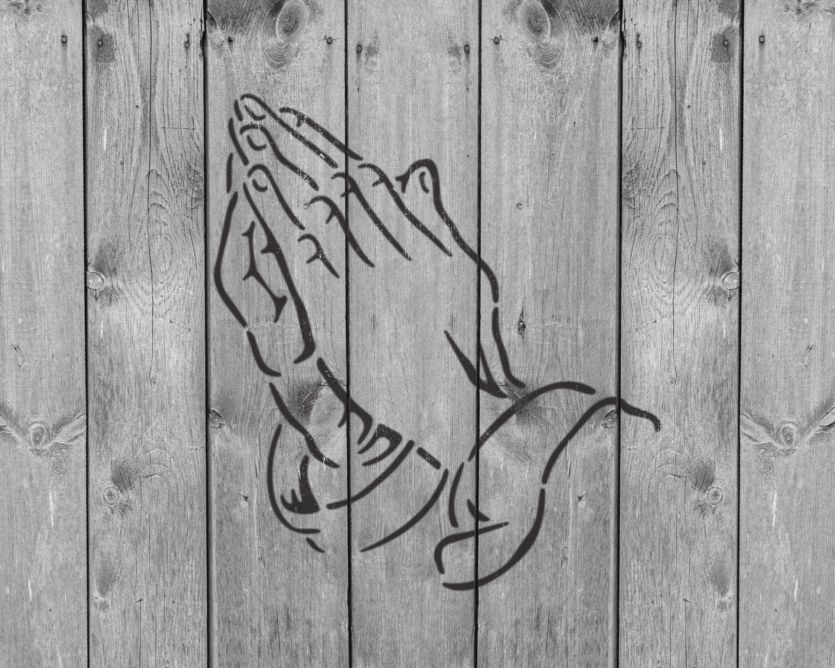 A black and white image of a praying hand on a wooden background.