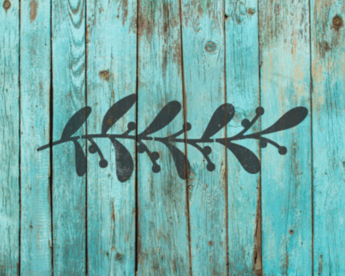 A black silhouette of a leaf or branch is superimposed on a weathered, blue wooden surface.