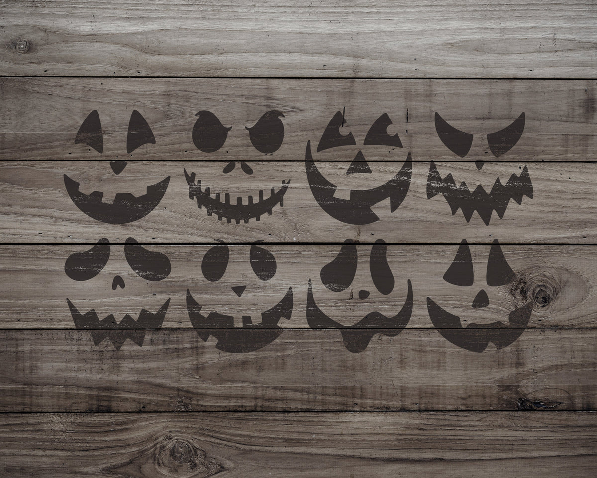 A collection of Halloween-themed jack-o'-lantern faces printed on a wooden surface.