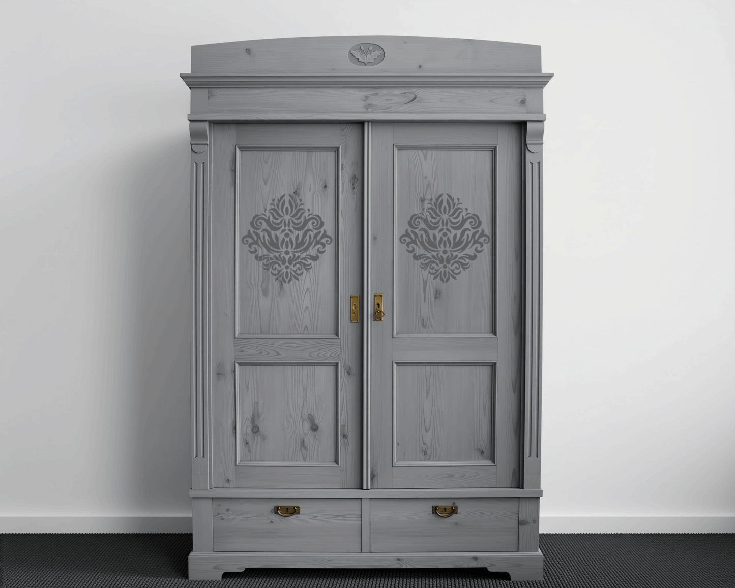 A gray wooden wardrobe with decorative elements on the doors, standing against a white wall.