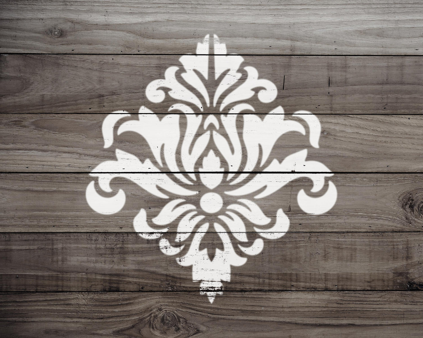 a white, ornate design resembling a floral pattern or a decorative element, painted on a wooden surface.