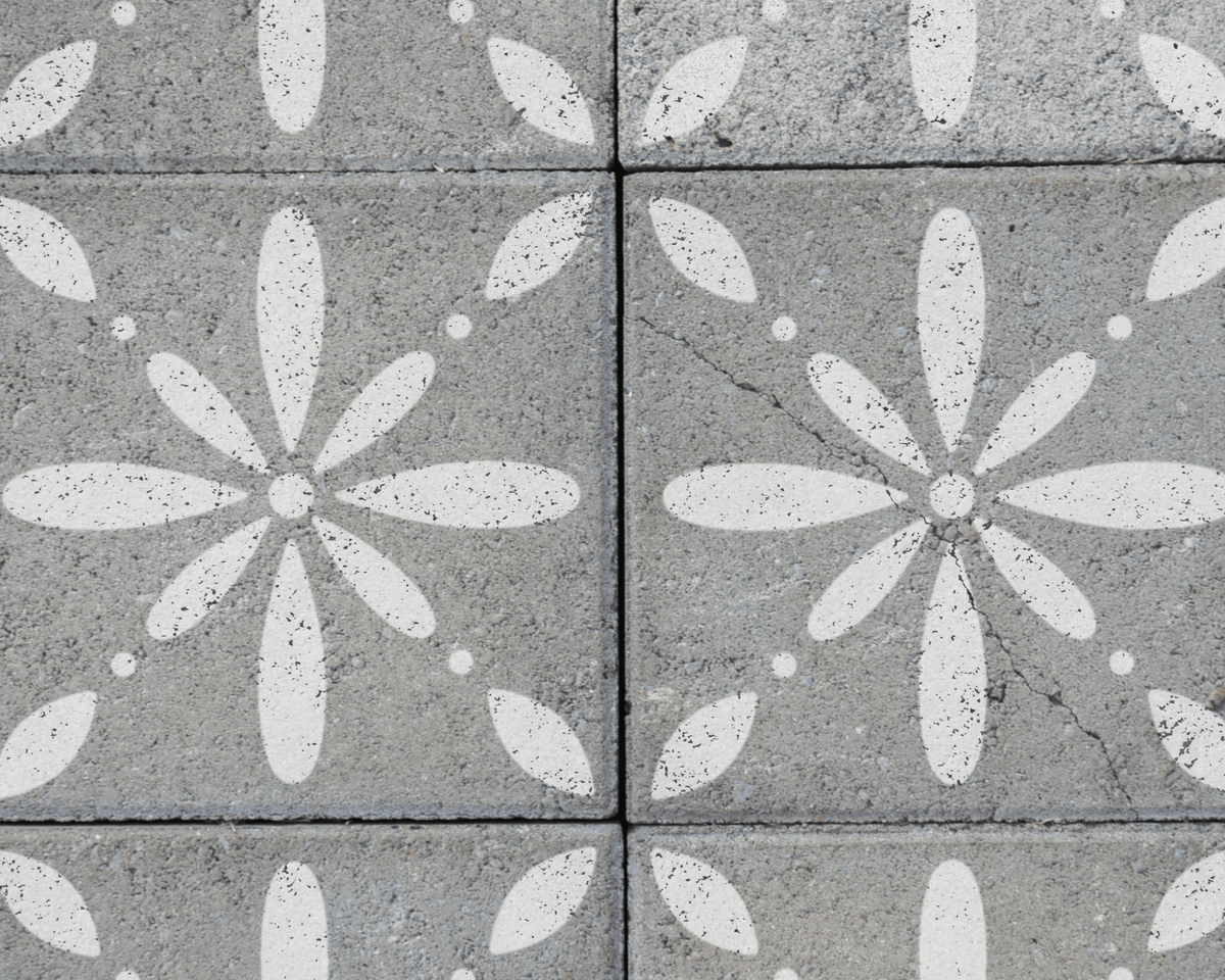 a close-up view of a patterned concrete surface with white flower-like designs.