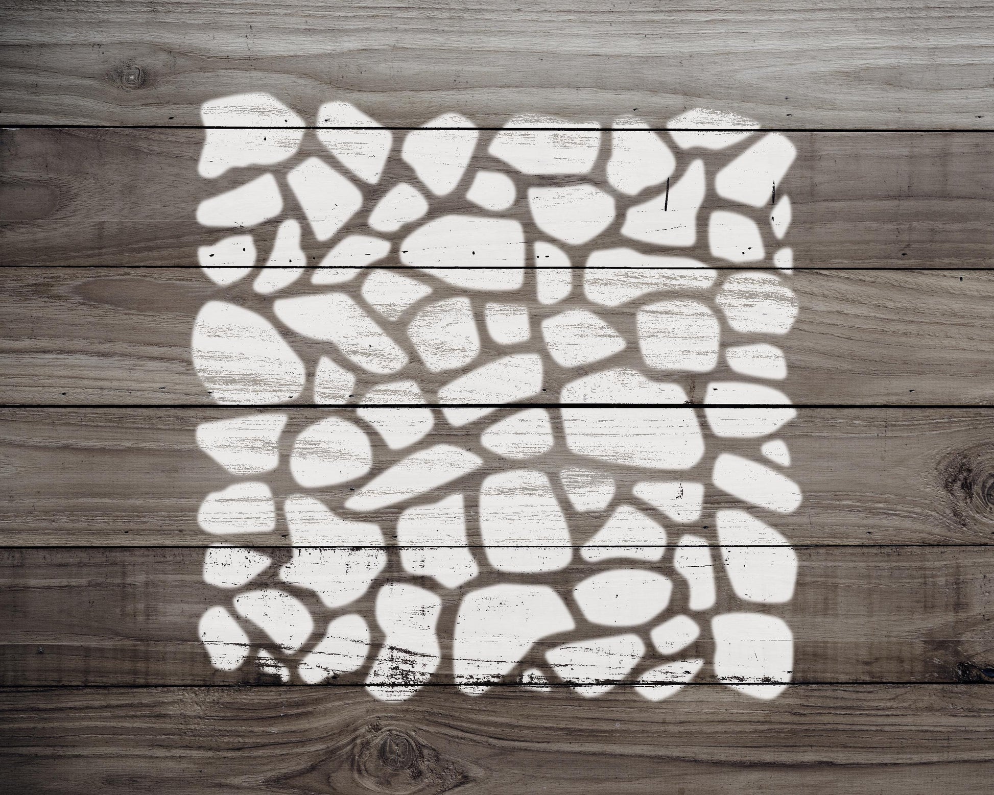 a wooden surface with a white, abstract pattern resembling a mosaic or stone design.