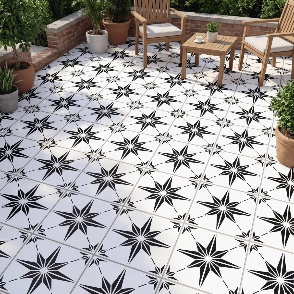 a patio area with a black and white star-patterned tile floor, surrounded by potted plants and wooden chairs.