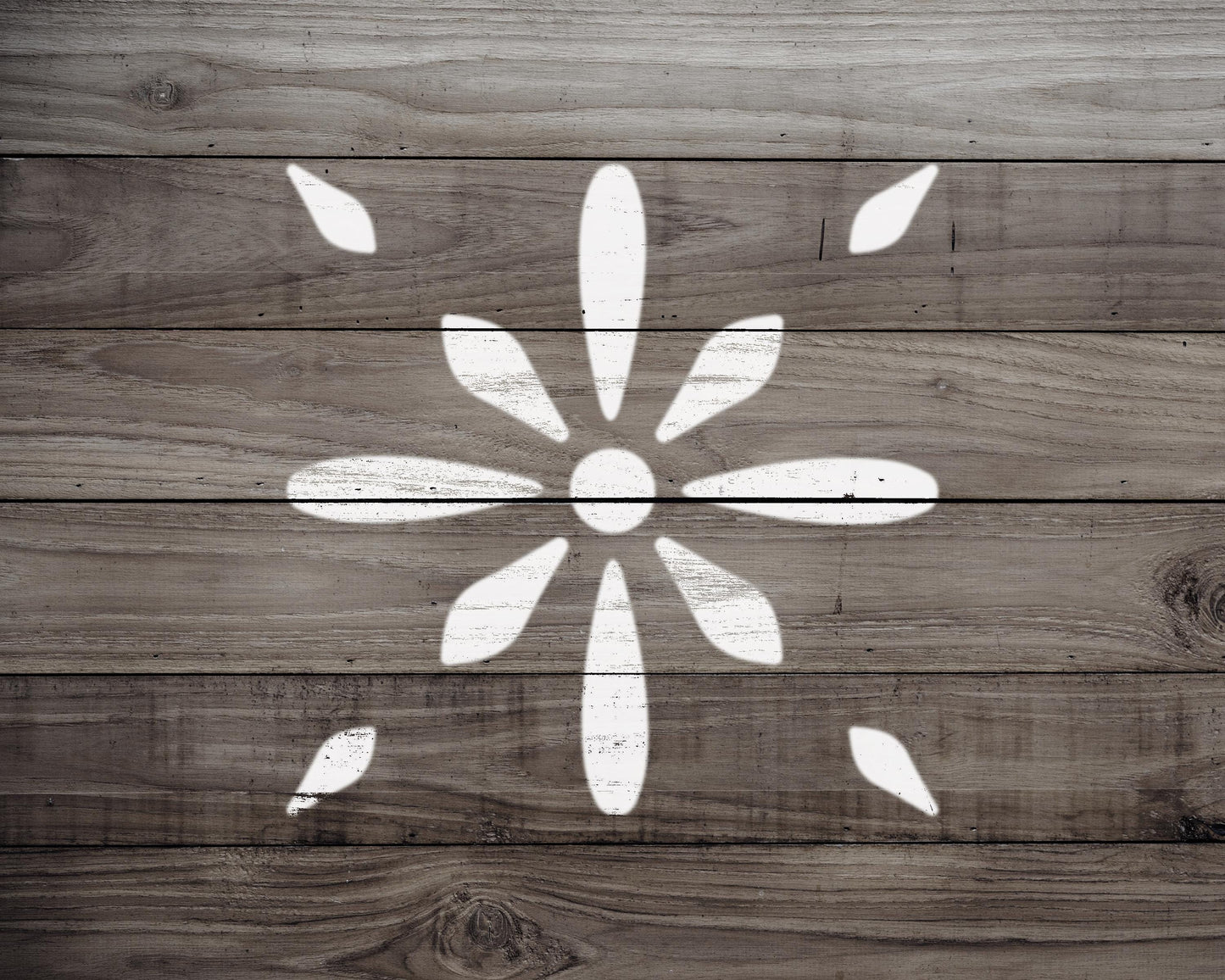 a wooden surface with a white flower-like design painted on it.