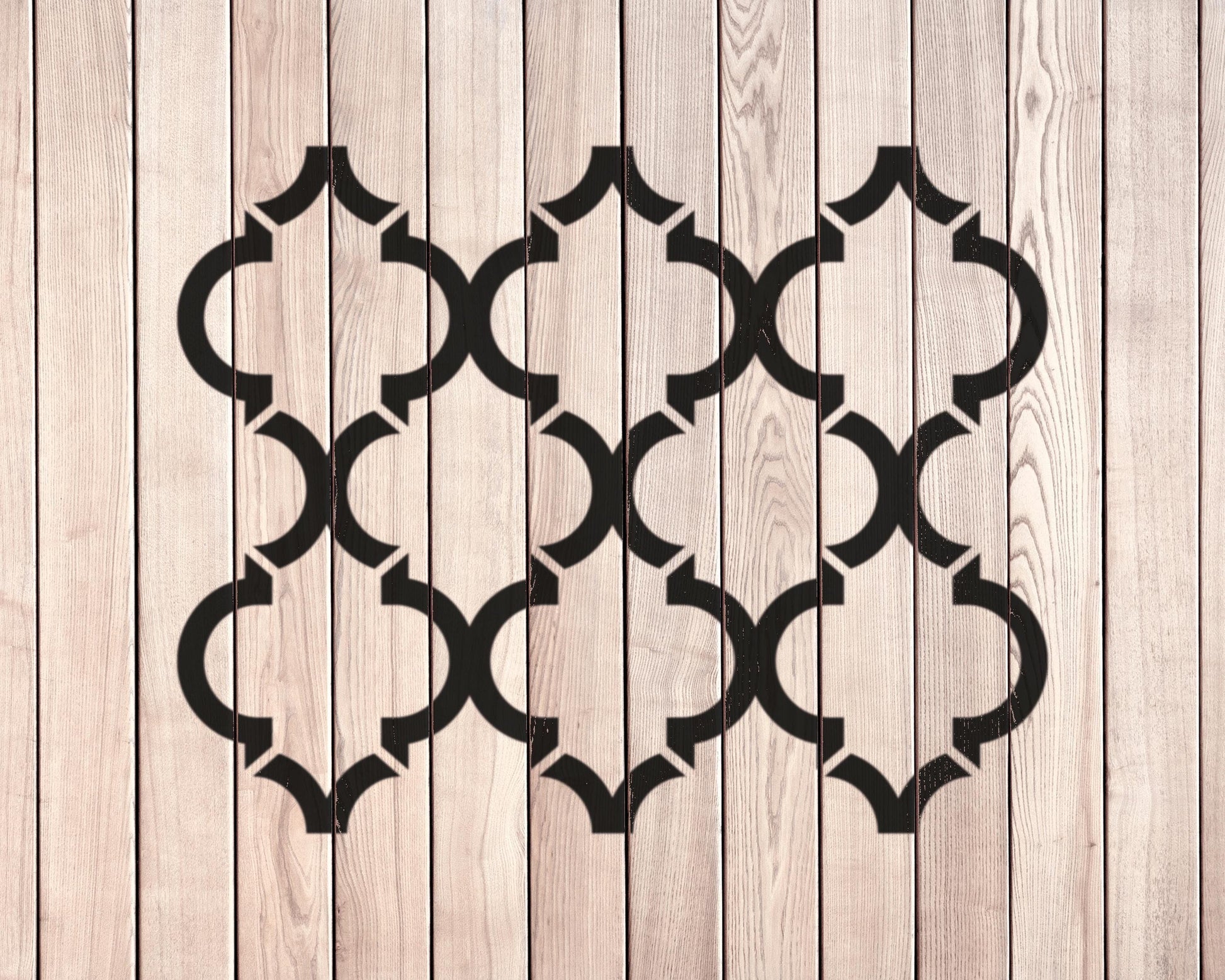 a wooden surface with a repeating pattern of black geometric shapes, creating a visually striking and symmetrical design.