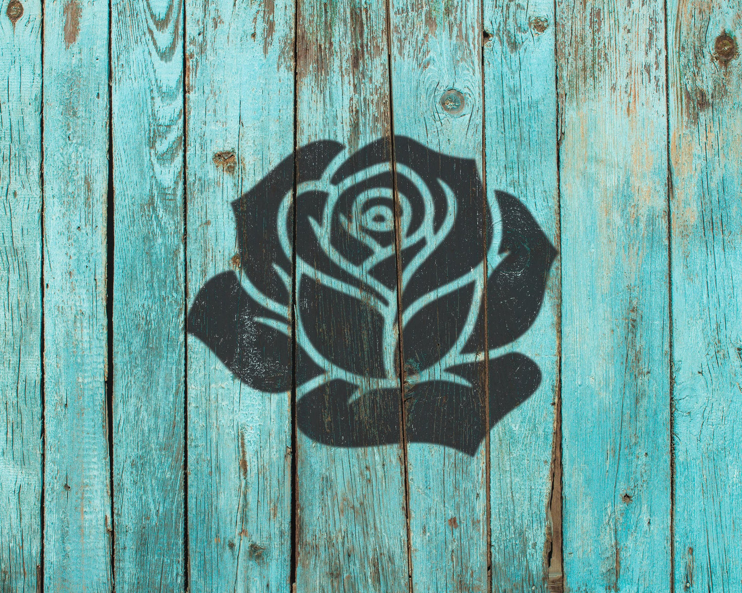 a black silhouette of a rose painted on a weathered, turquoise wooden surface.