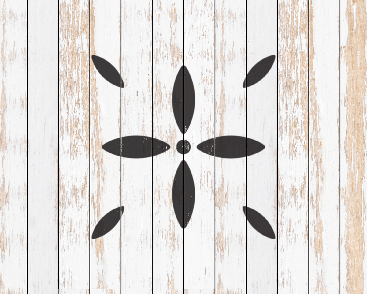 a close-up view of a white wooden surface with a black flower-like design in the center.