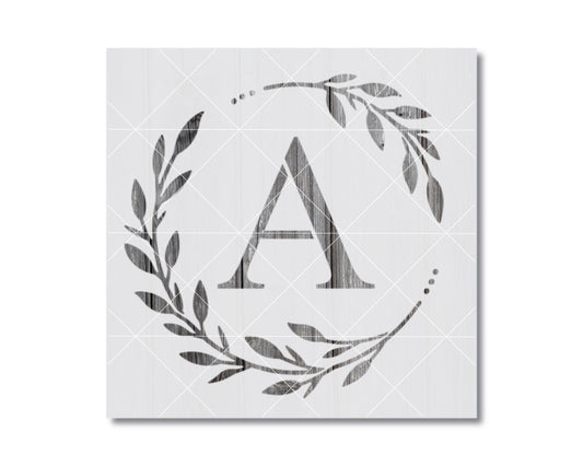 A monogrammed letter "A" surrounded by a wreath of leaves and branches, all rendered in a black and white style.