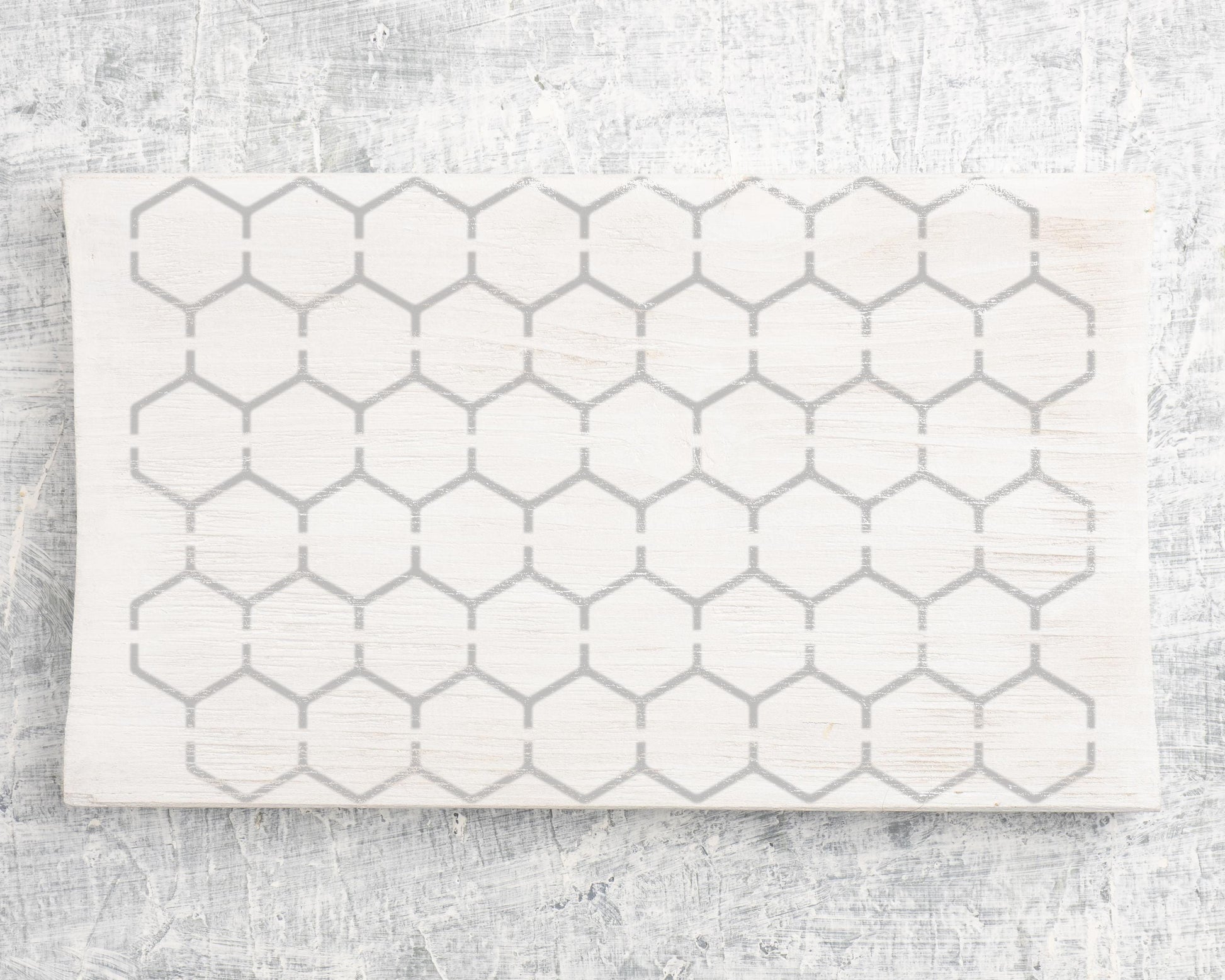 a white surface with a repeating pattern of gray hexagons.