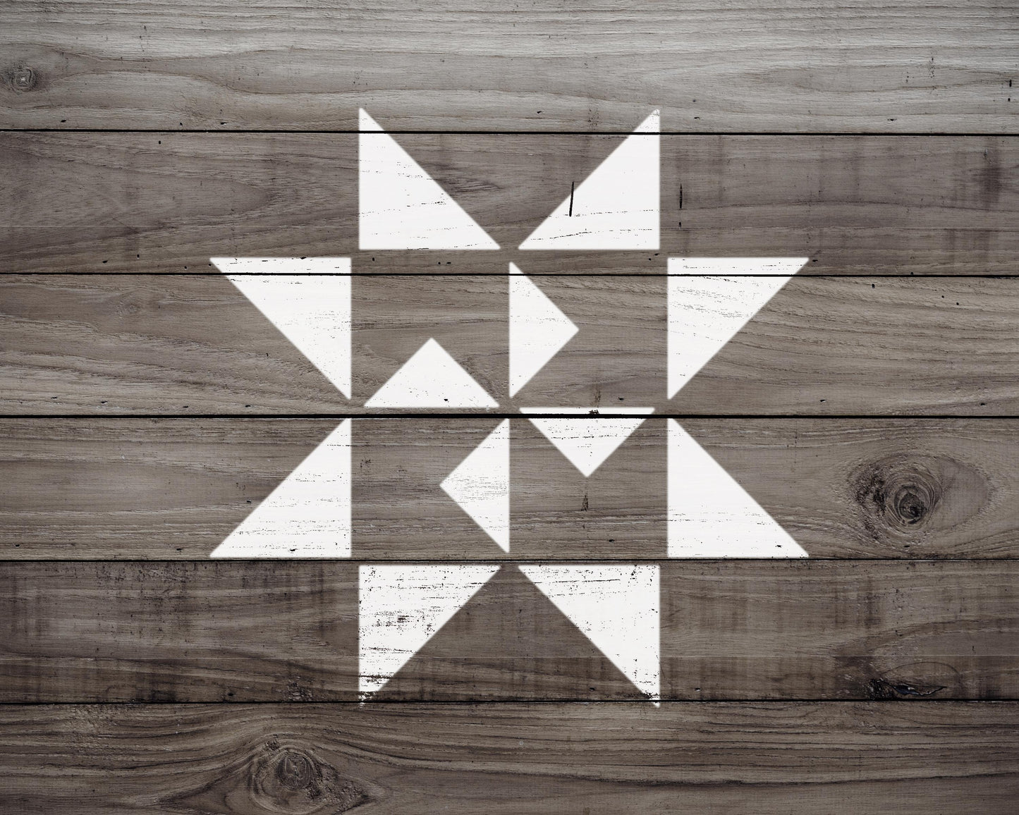 a wooden surface with a geometric pattern of white triangles arranged in a star-like shape.