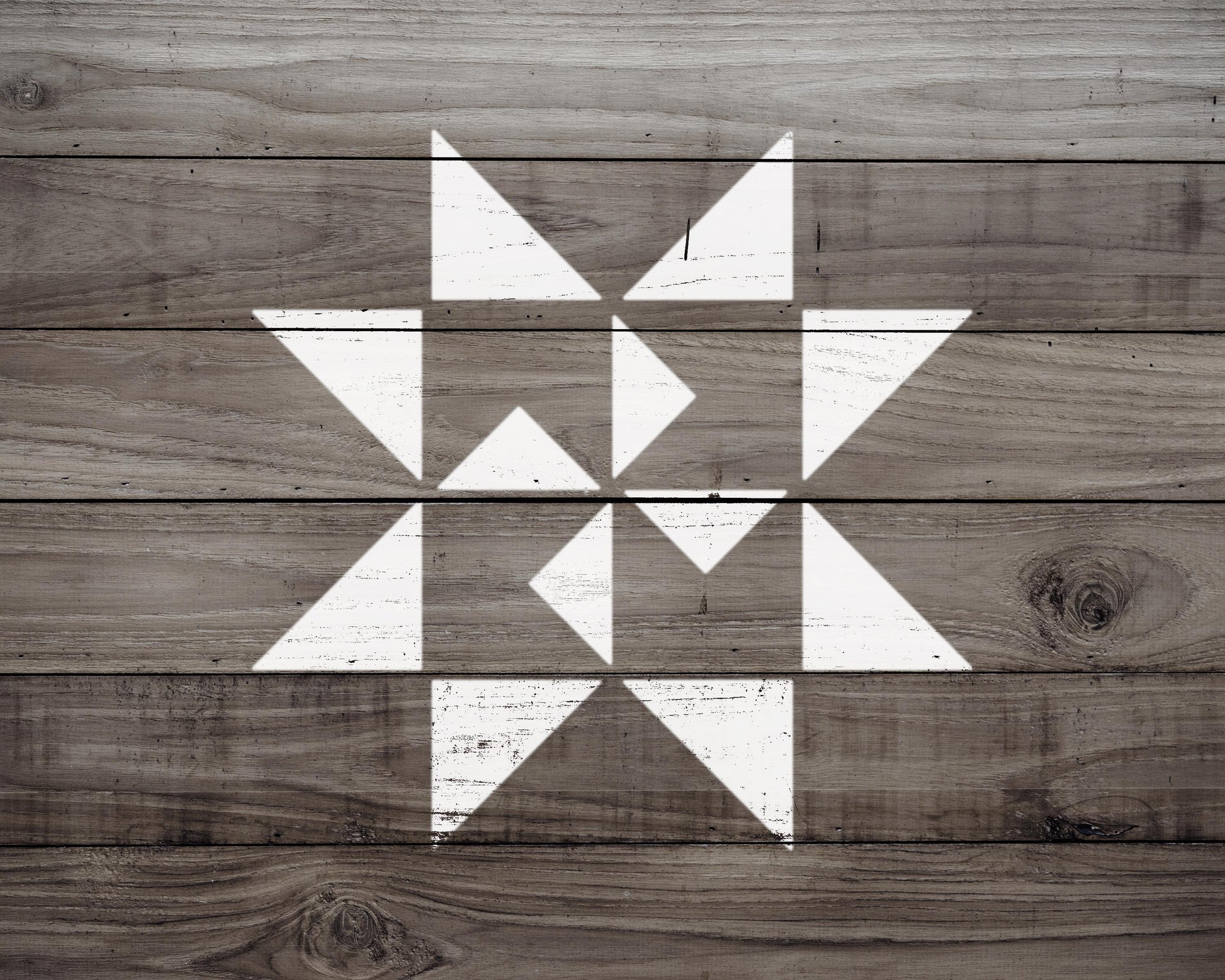 a wooden surface with a geometric pattern of white triangles arranged in a star-like shape.