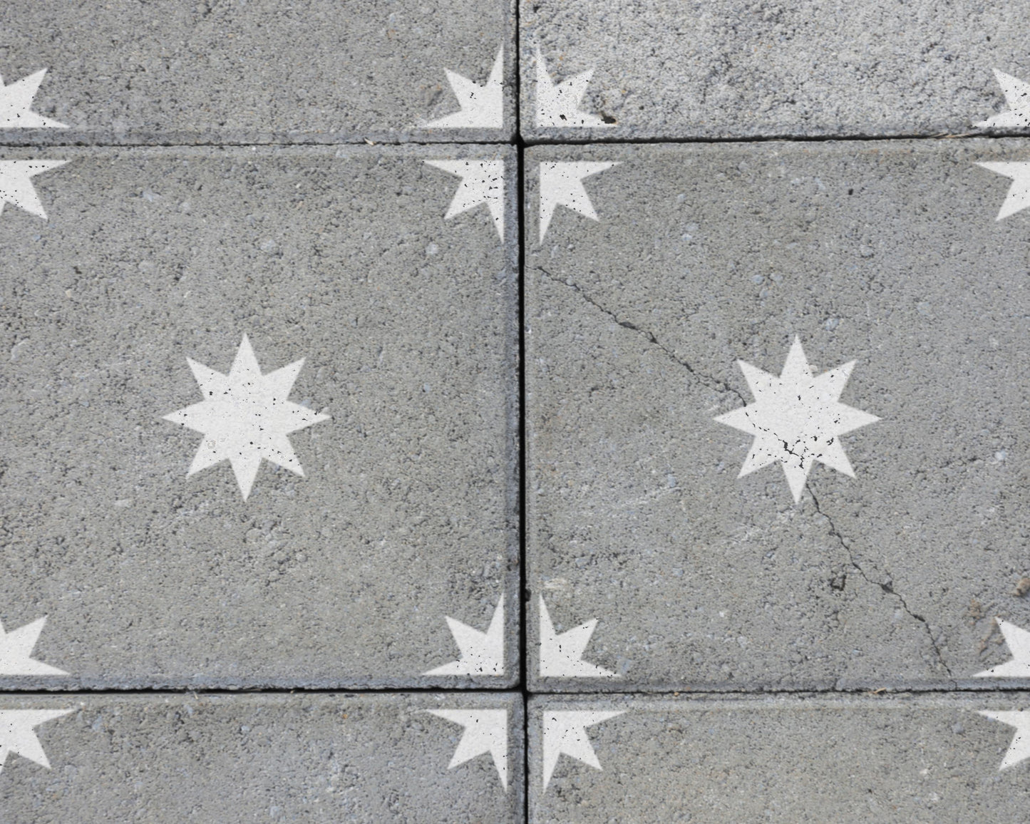 a close-up view of a concrete surface with white star-shaped patterns painted on it.