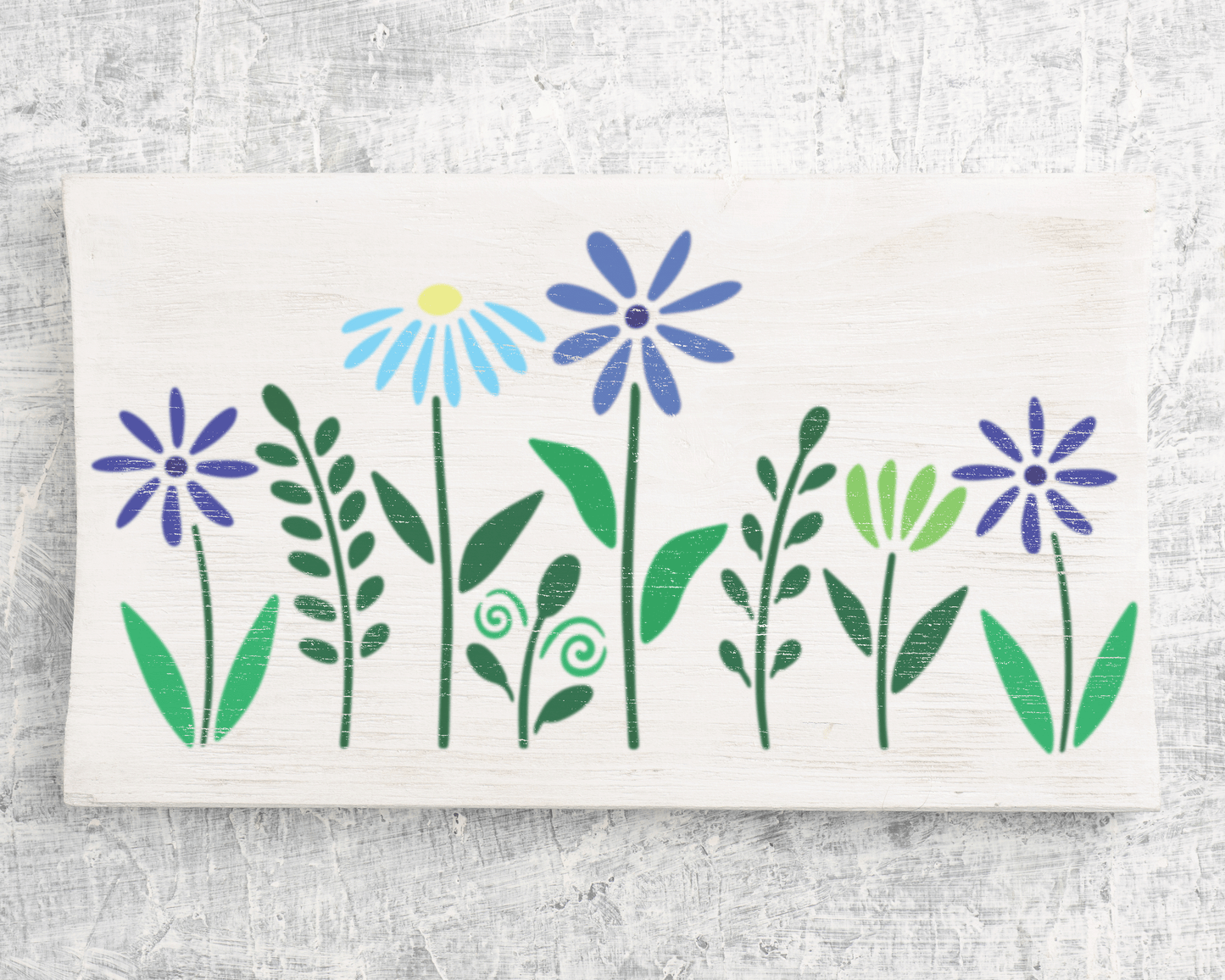 A white wooden surface with a floral design featuring blue and purple flowers along with green leaves.