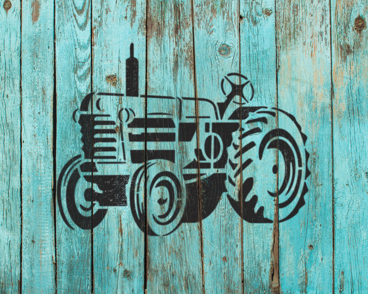 A black silhouette of a tractor is painted on a weathered blue wooden surface.