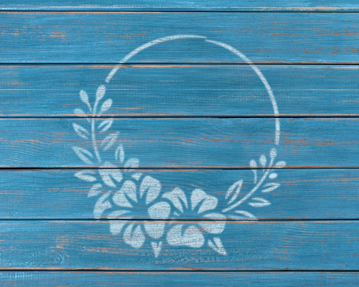a blue wooden surface with a white floral wreath design painted on it.