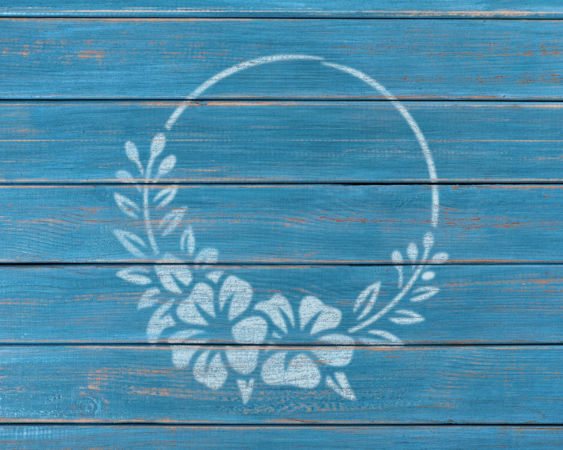 a blue wooden surface with a white floral wreath design painted on it.