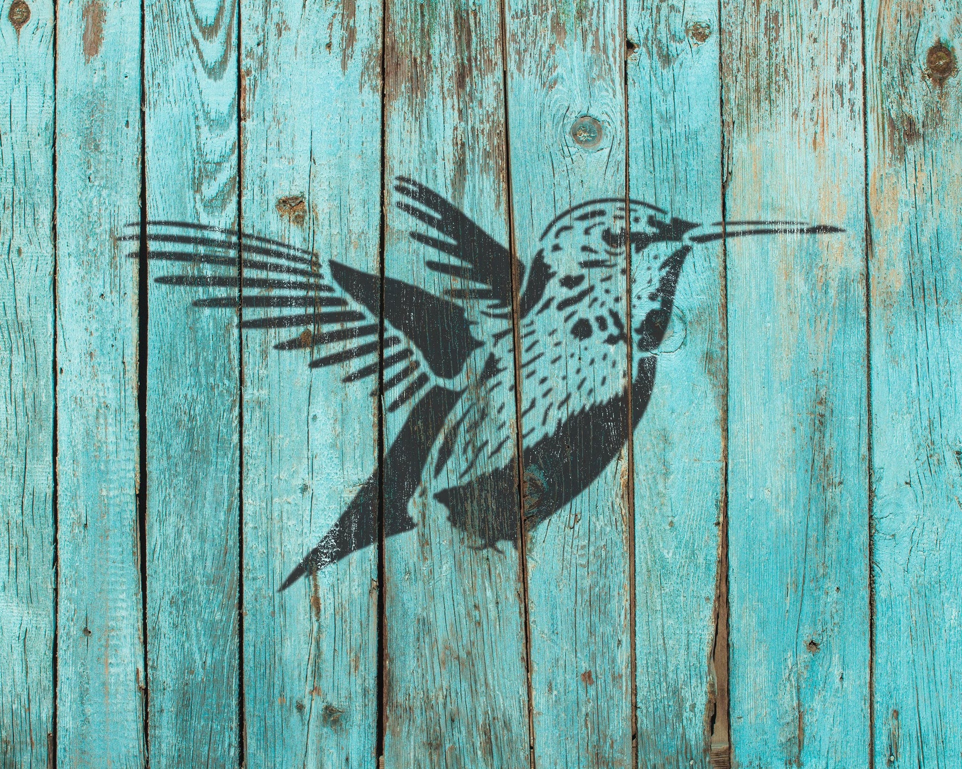 a black silhouette of a bird with outstretched wings against a blue wooden background.