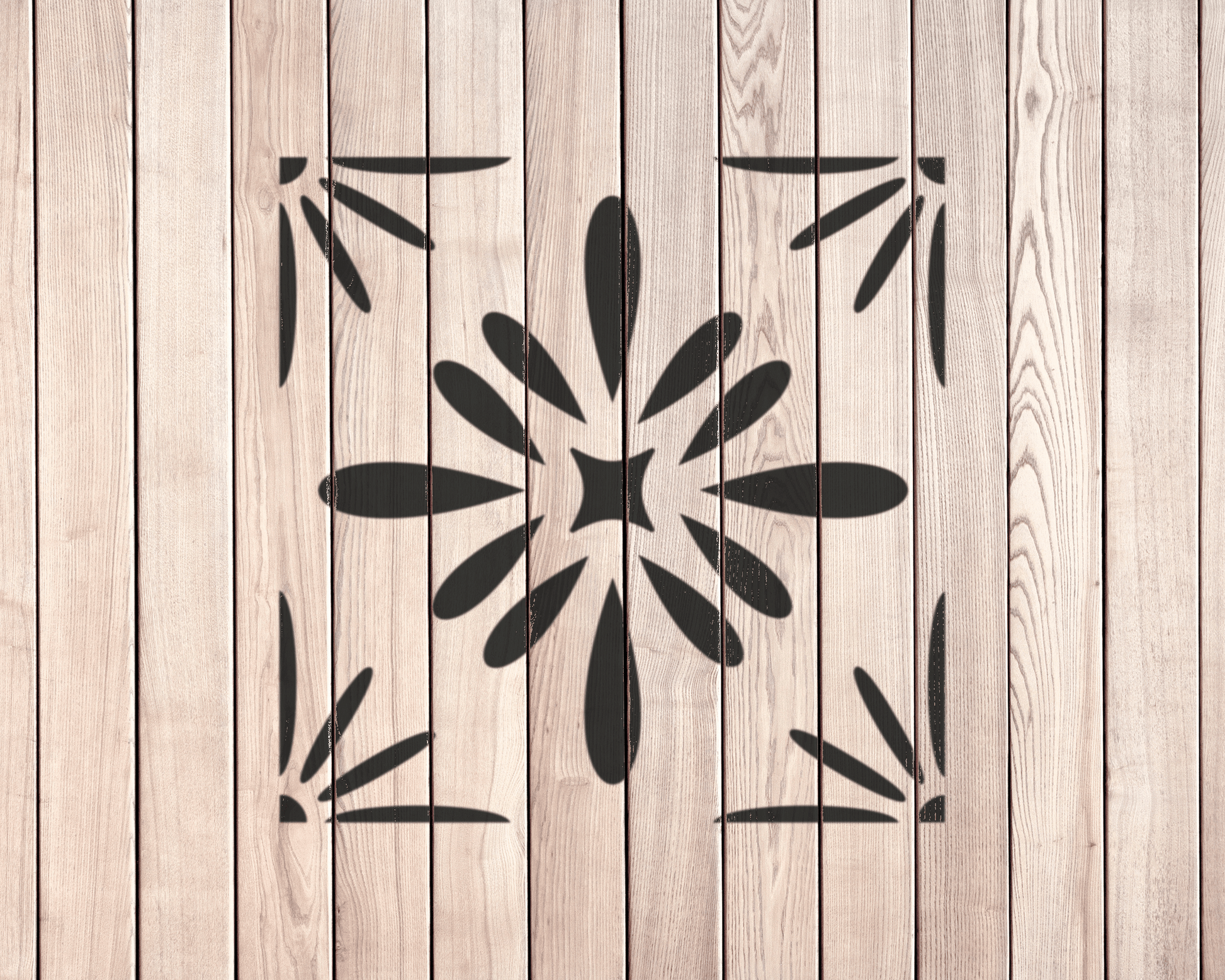 a wooden surface with a black stencil design in the center.