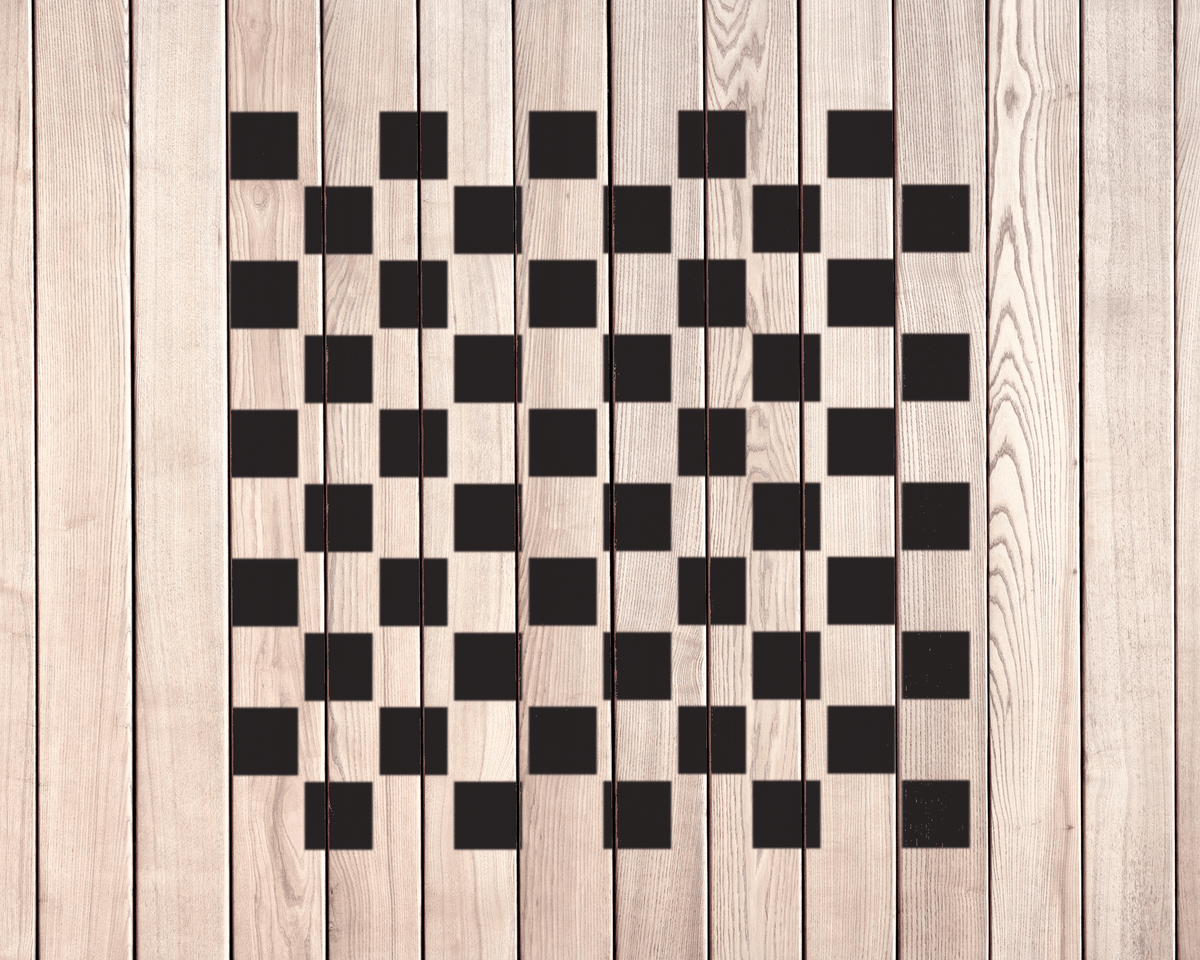 a wooden surface with a checkerboard pattern of black squares arranged in a grid-like pattern.