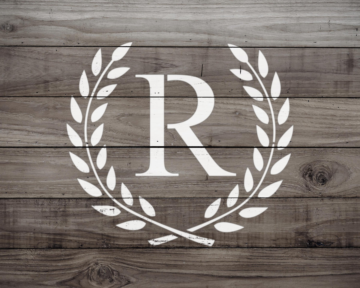 a monogrammed logo consisting of a large "R" surrounded by a laurel wreath, all set against a wooden background.