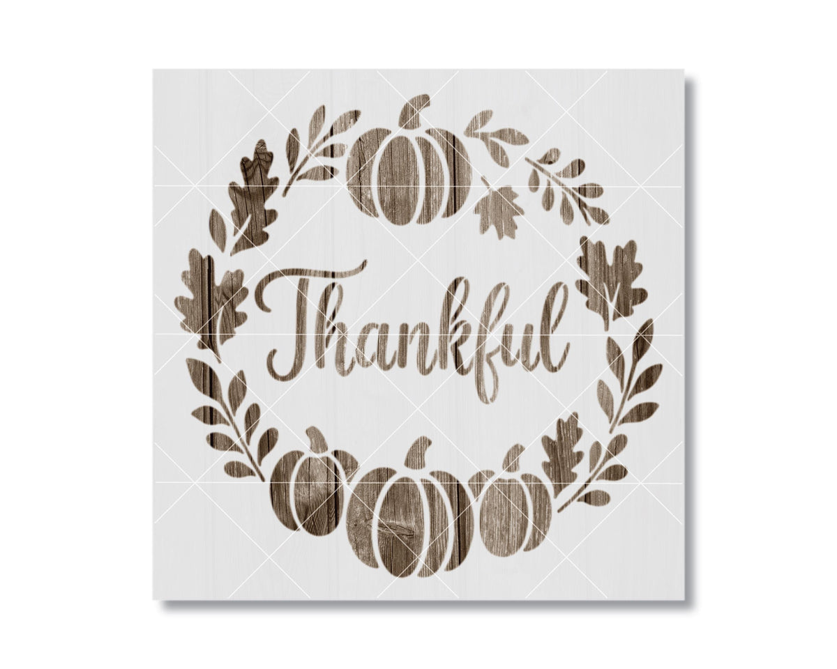 A wreath made of leaves and pumpkins with the word "Thankful" written on it.