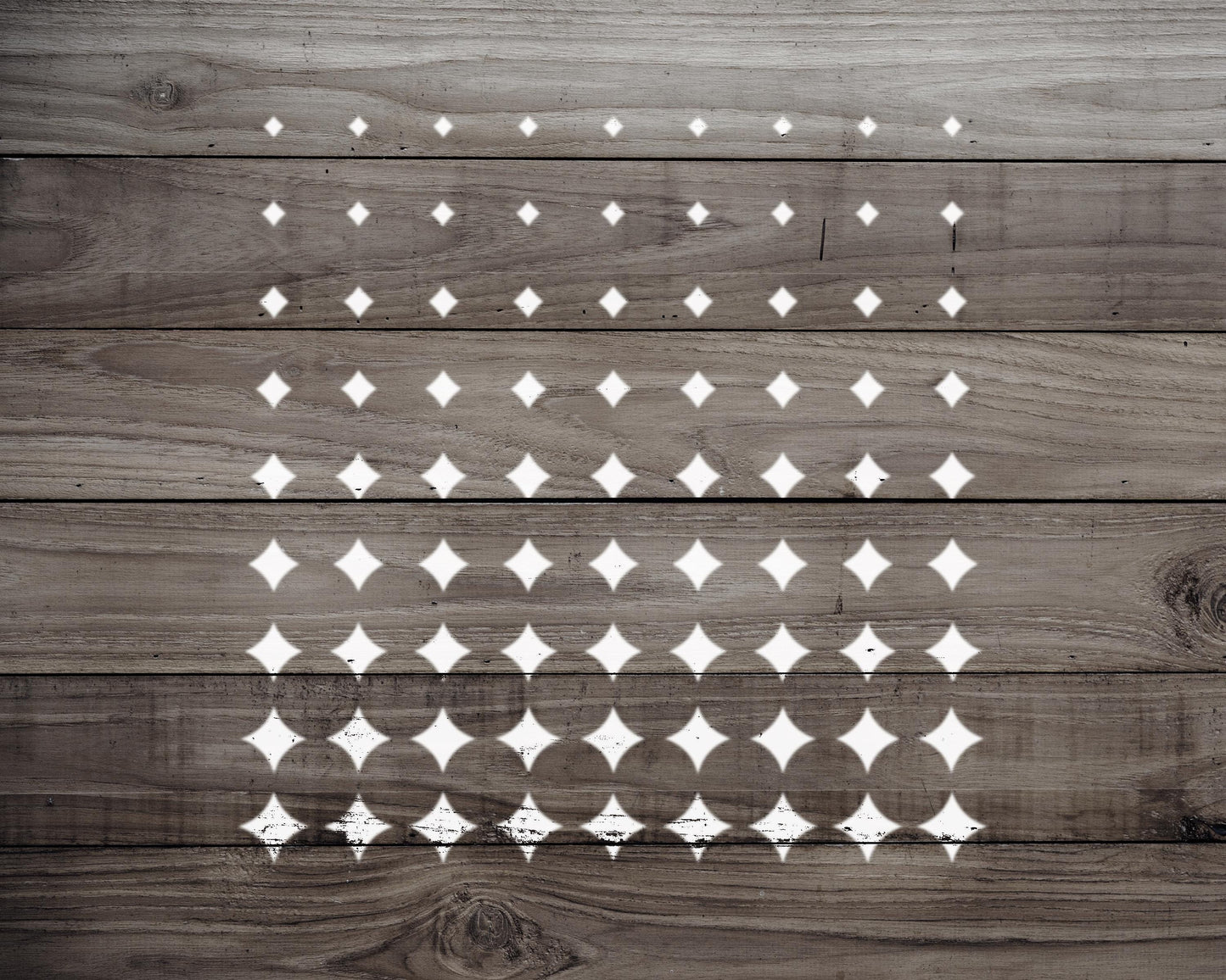 a wooden surface with a repeating pattern of white diamond shapes, creating a visually striking and geometric design.