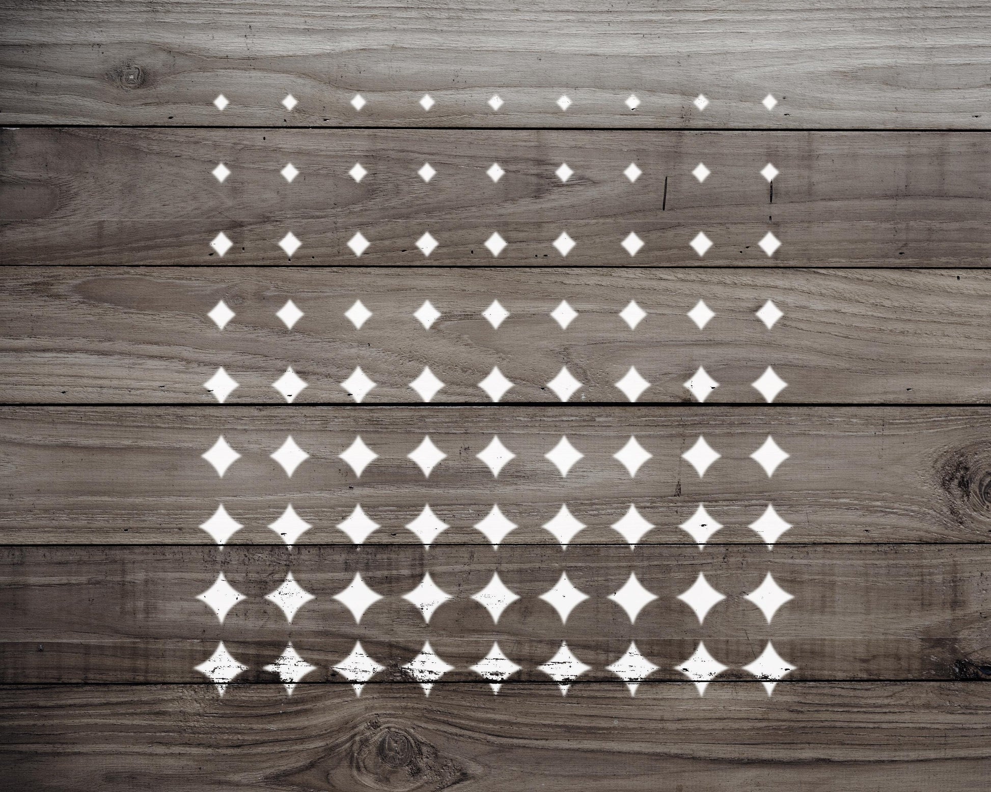 a wooden surface with a repeating pattern of white diamond shapes, creating a visually striking and geometric design.