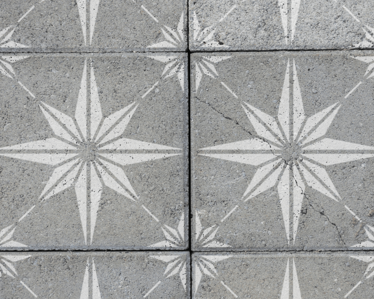 a close-up view of a concrete surface with a repeating pattern of white star-shaped designs.