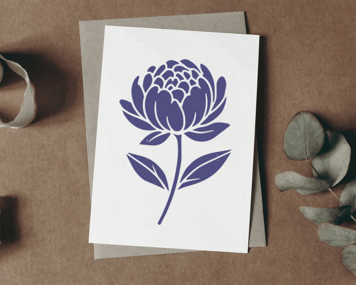 a white card with a blue flower design on it, placed on a brown surface.