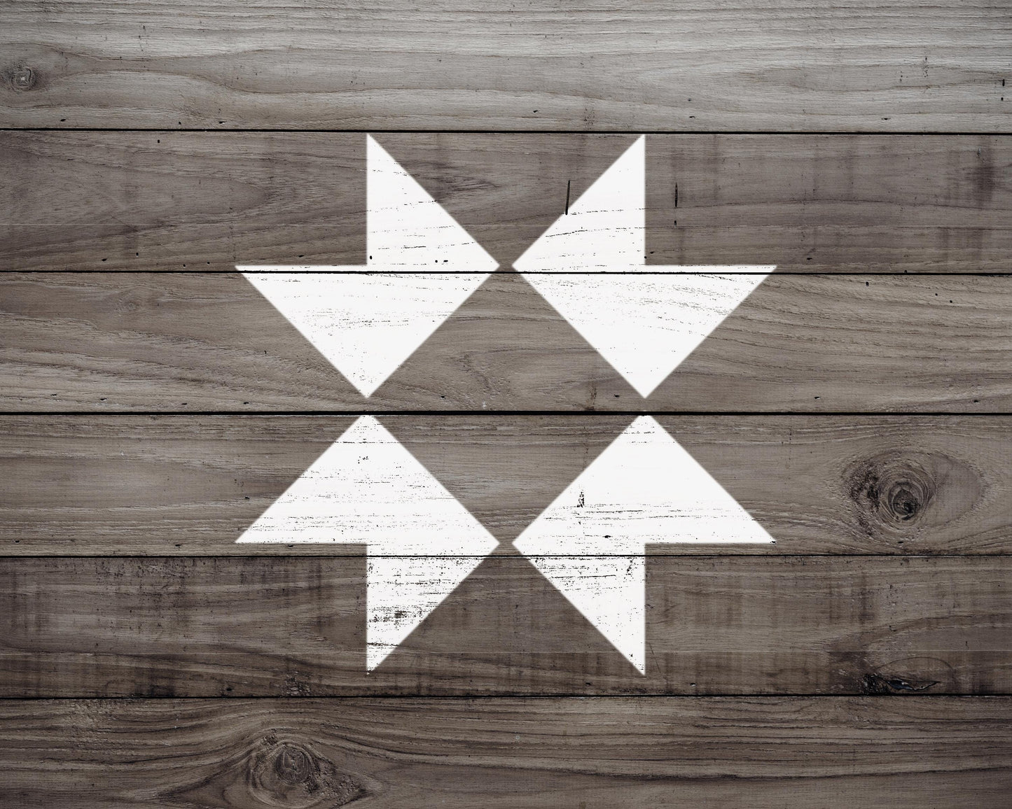a close-up view of a wooden surface with a white arrow design in the center.