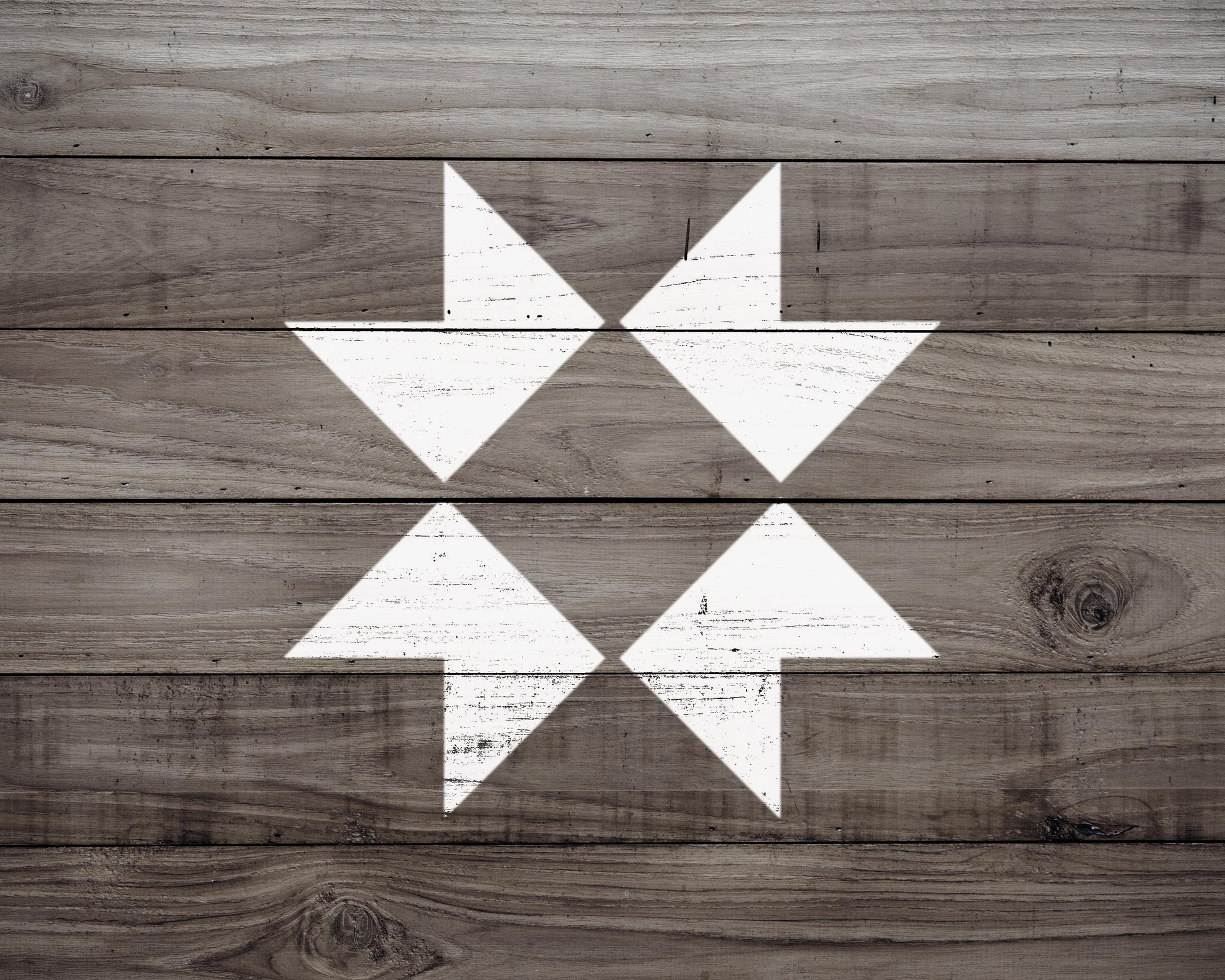 a close-up view of a wooden surface with a white arrow design in the center.