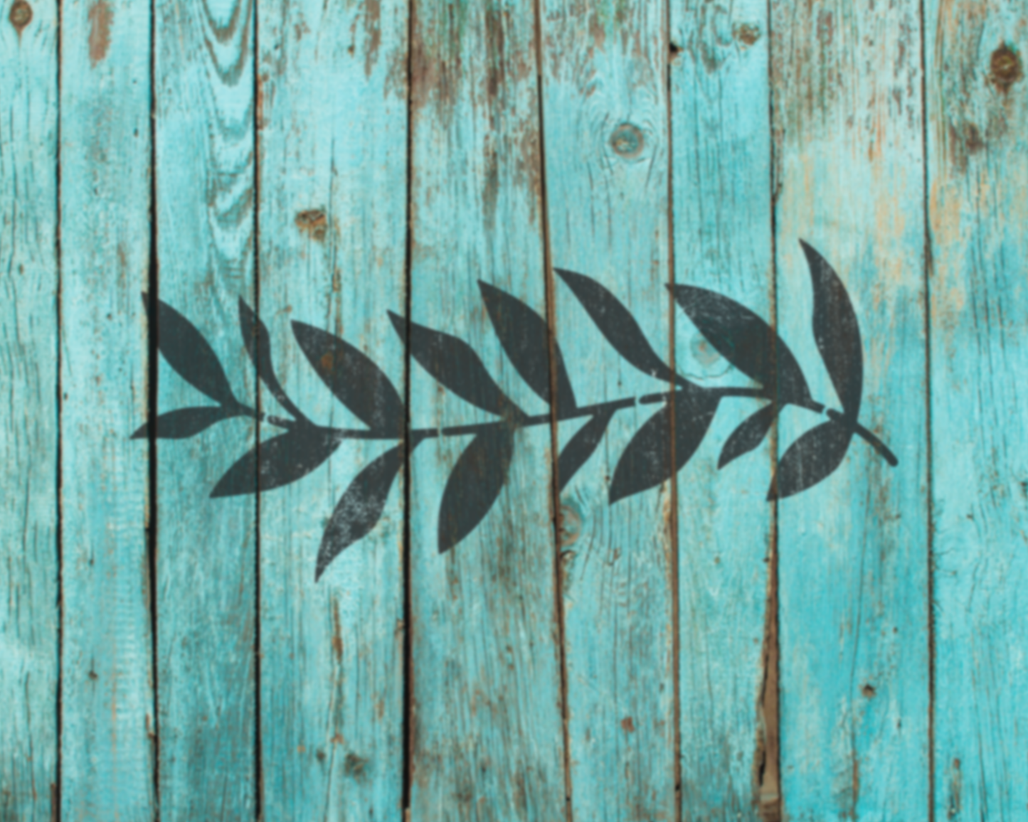 a close-up view of a weathered wooden surface with a blue-green hue. There is a black silhouette of a leaf-like shape or design, which appears to be a stylized representation of a leaf or branch.