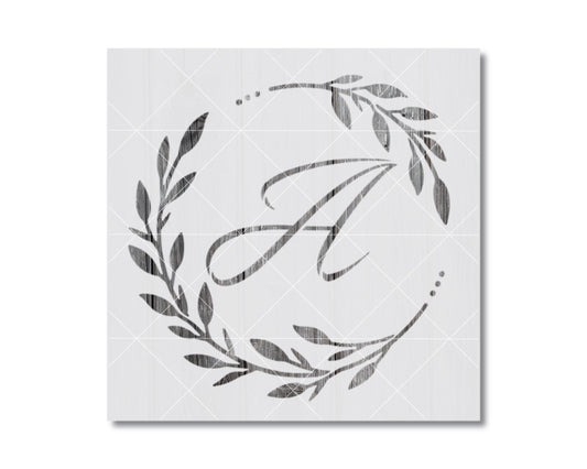 A monogrammed letter "A" surrounded by a decorative wreath of leaves and branches.