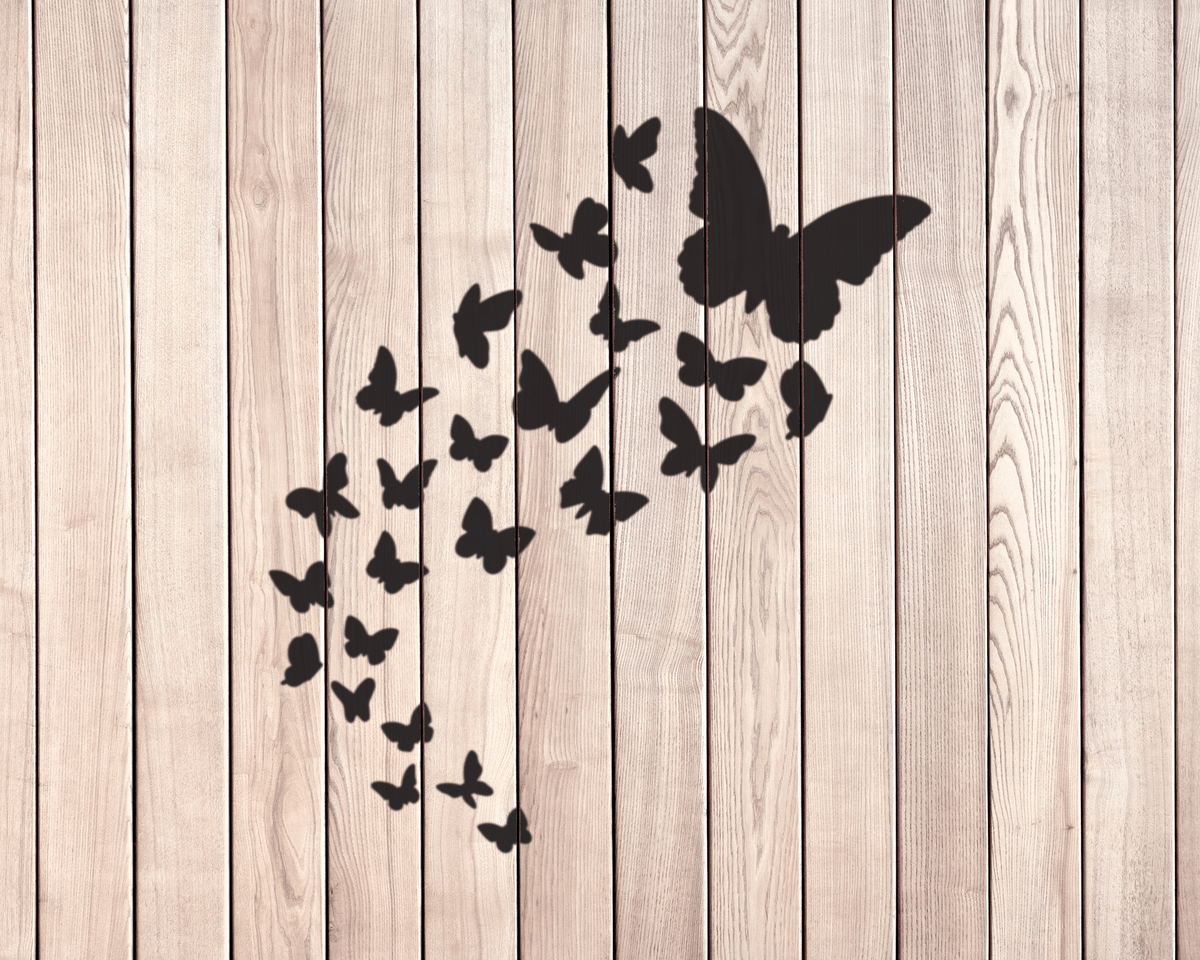 a collection of black silhouettes of butterflies against a wooden background.