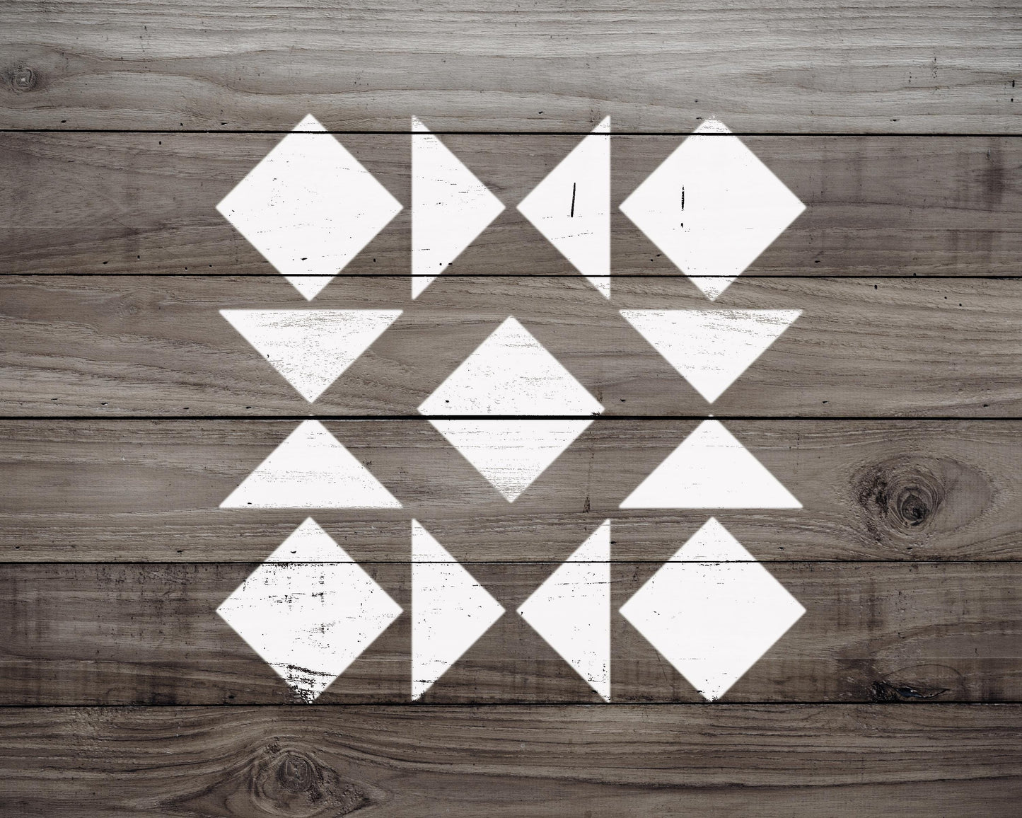 a wooden surface with a geometric pattern of white triangles arranged in a diamond shape.