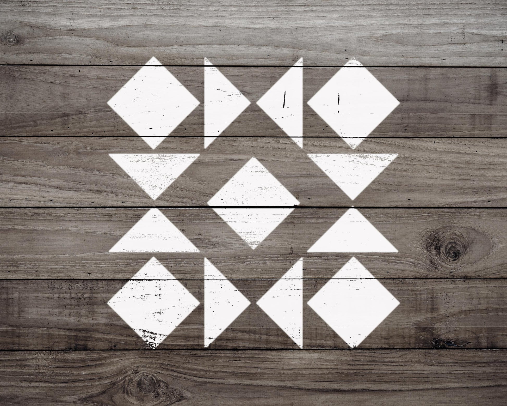 a wooden surface with a geometric pattern of white triangles arranged in a diamond shape.