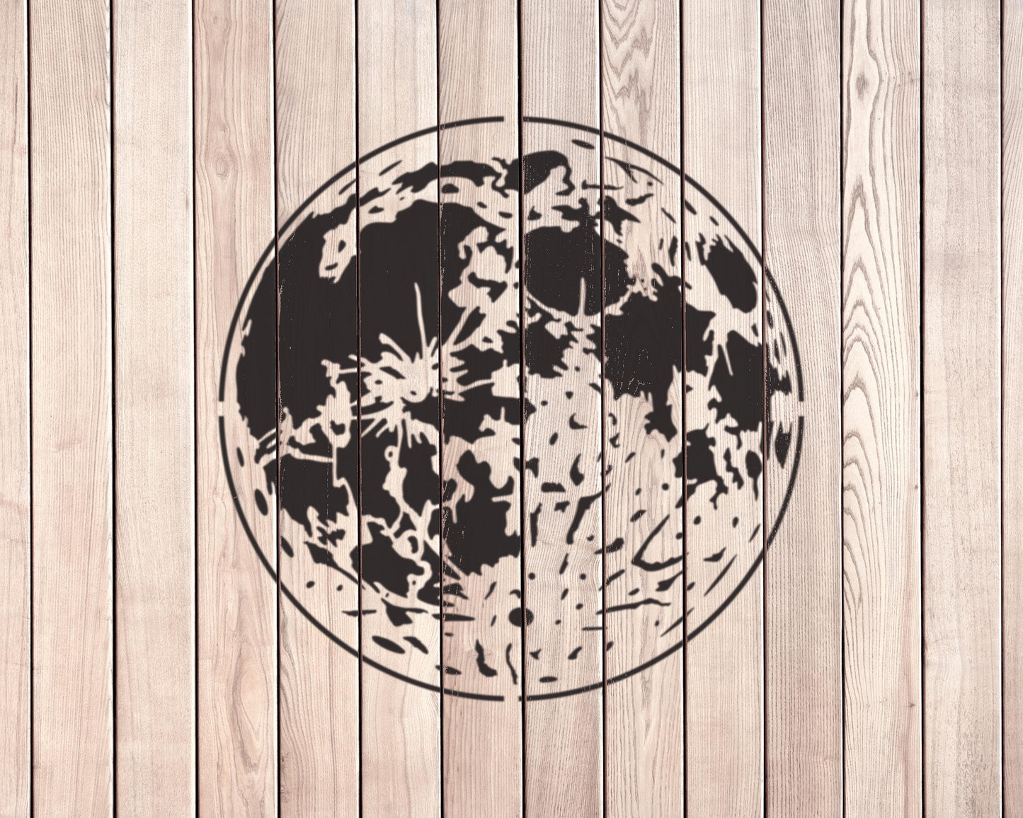 a large, circular black and white design resembling a moon or planet on a wooden background.