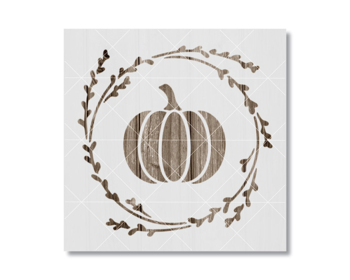 A white square with a wooden pumpkin silhouette and a wreath of leaves surrounding it.