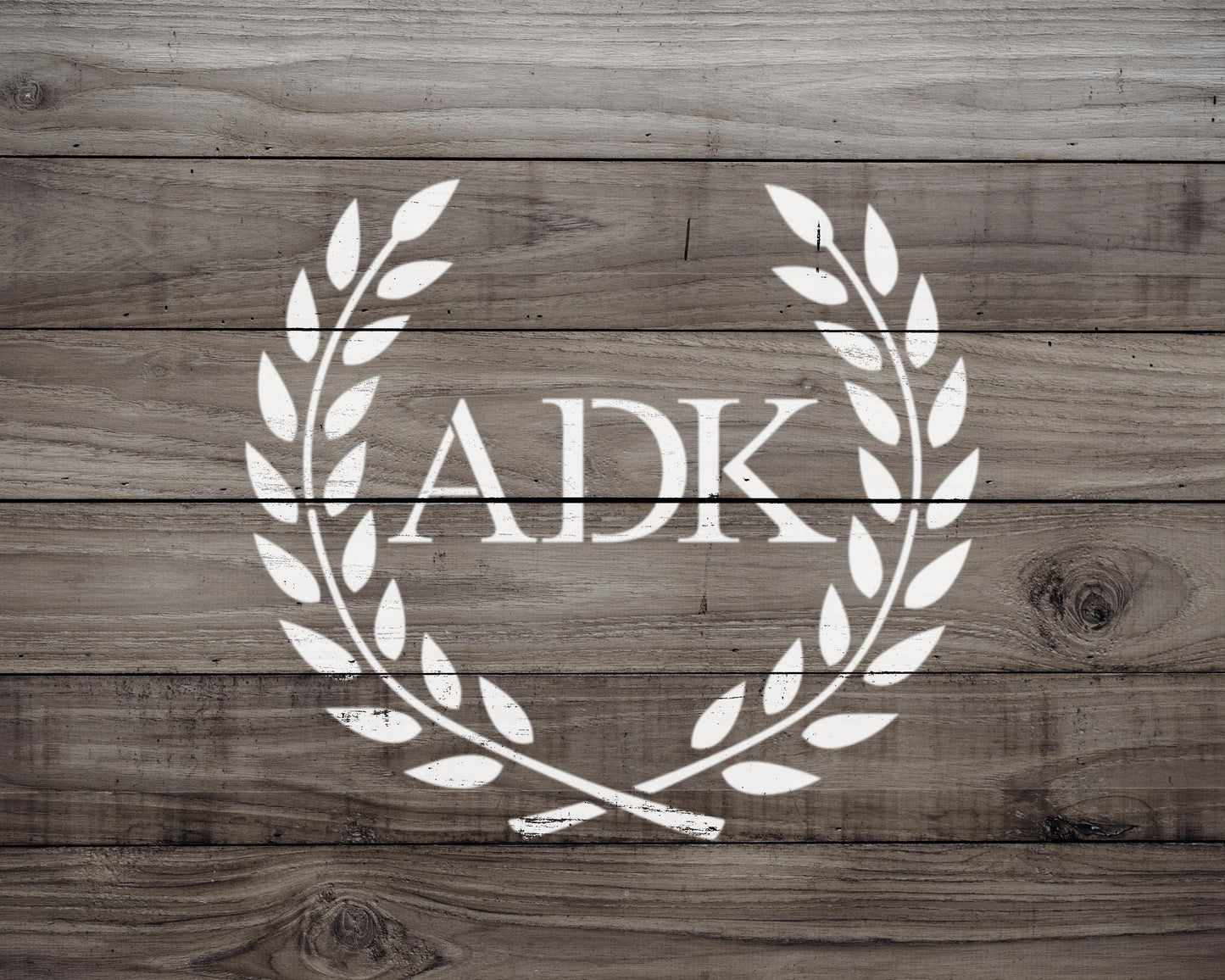 a logo with the letters 'ADK' in the center, surrounded by a laurel wreath design.