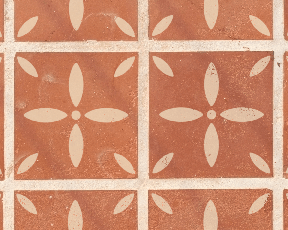 a close-up view of a patterned tile surface with a repeating design of white flower-like shapes.