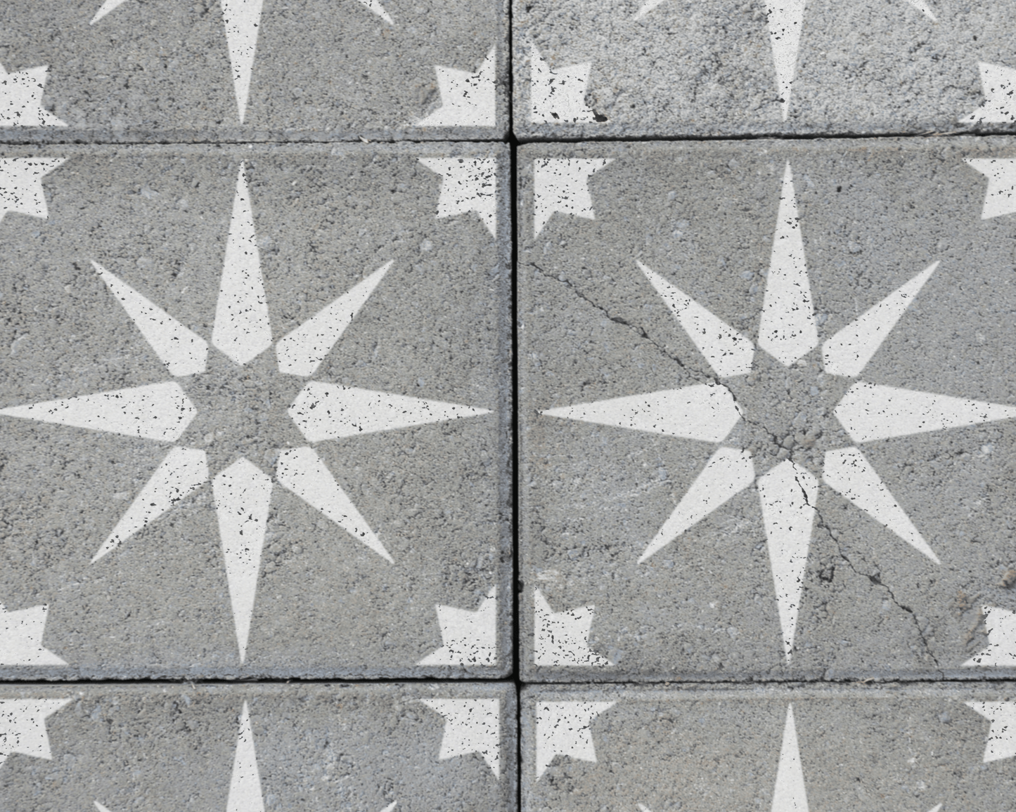 a close-up view of a concrete surface with a repeating pattern of white star-shaped designs.