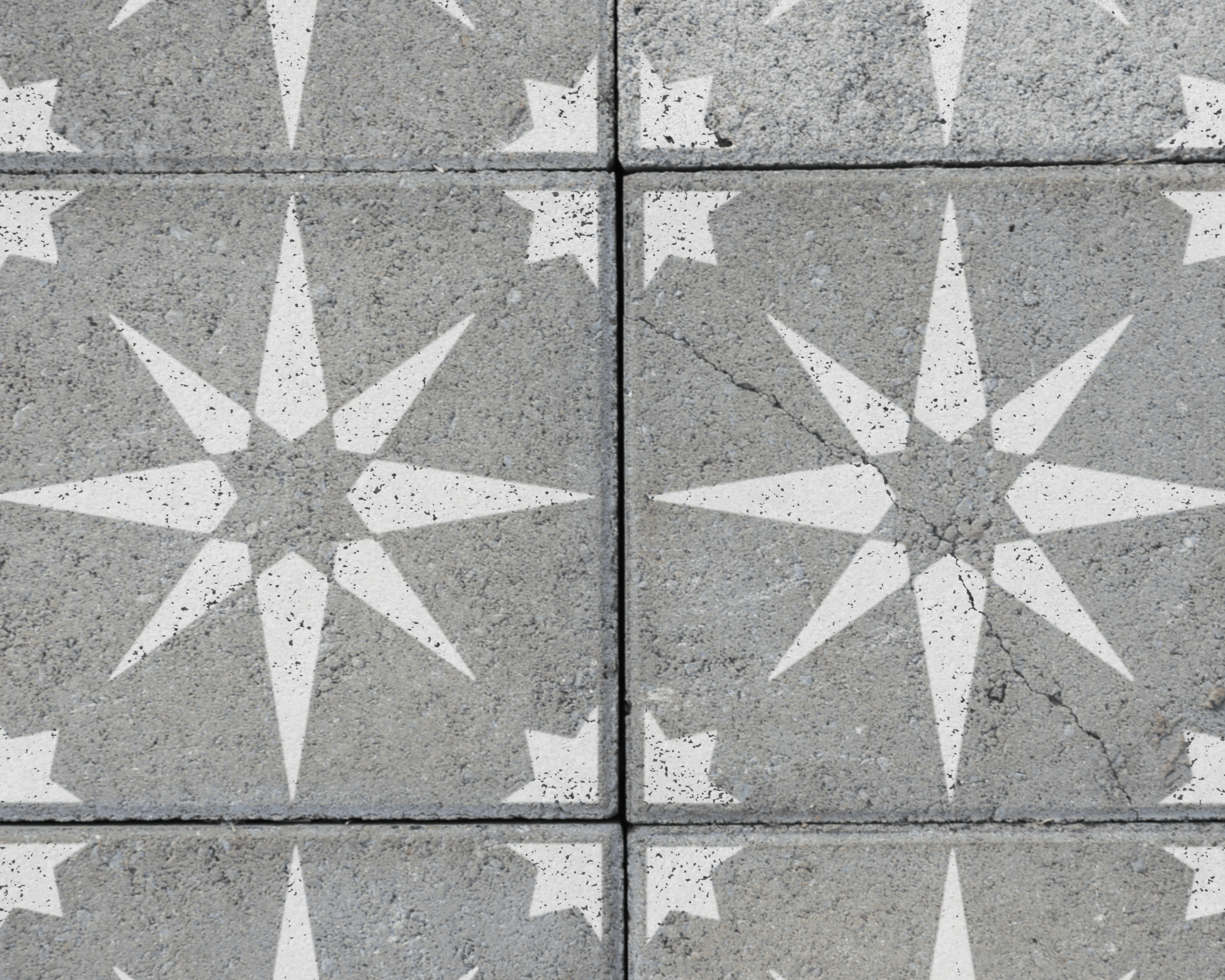 a close-up view of a concrete surface with a repeating pattern of white star-shaped designs.
