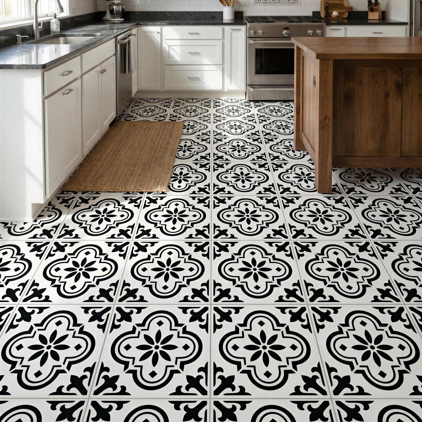 a kitchen with a black and white tile floor and white cabinets. The floor is covered in a patterned tile design, and the cabinets have a white finish. The kitchen appears to be well-lit and clean, with a wooden island and a rug on the floor.