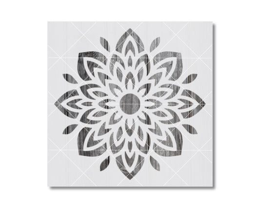 a symmetrical, intricate floral design with a central circle surrounded by a multitude of petals and leaves in a black and white color scheme.