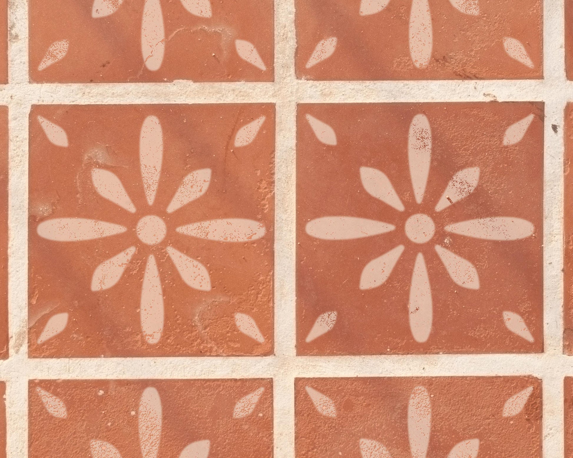 a close-up view of a patterned tile surface with a repeating design of white flowers or petals.