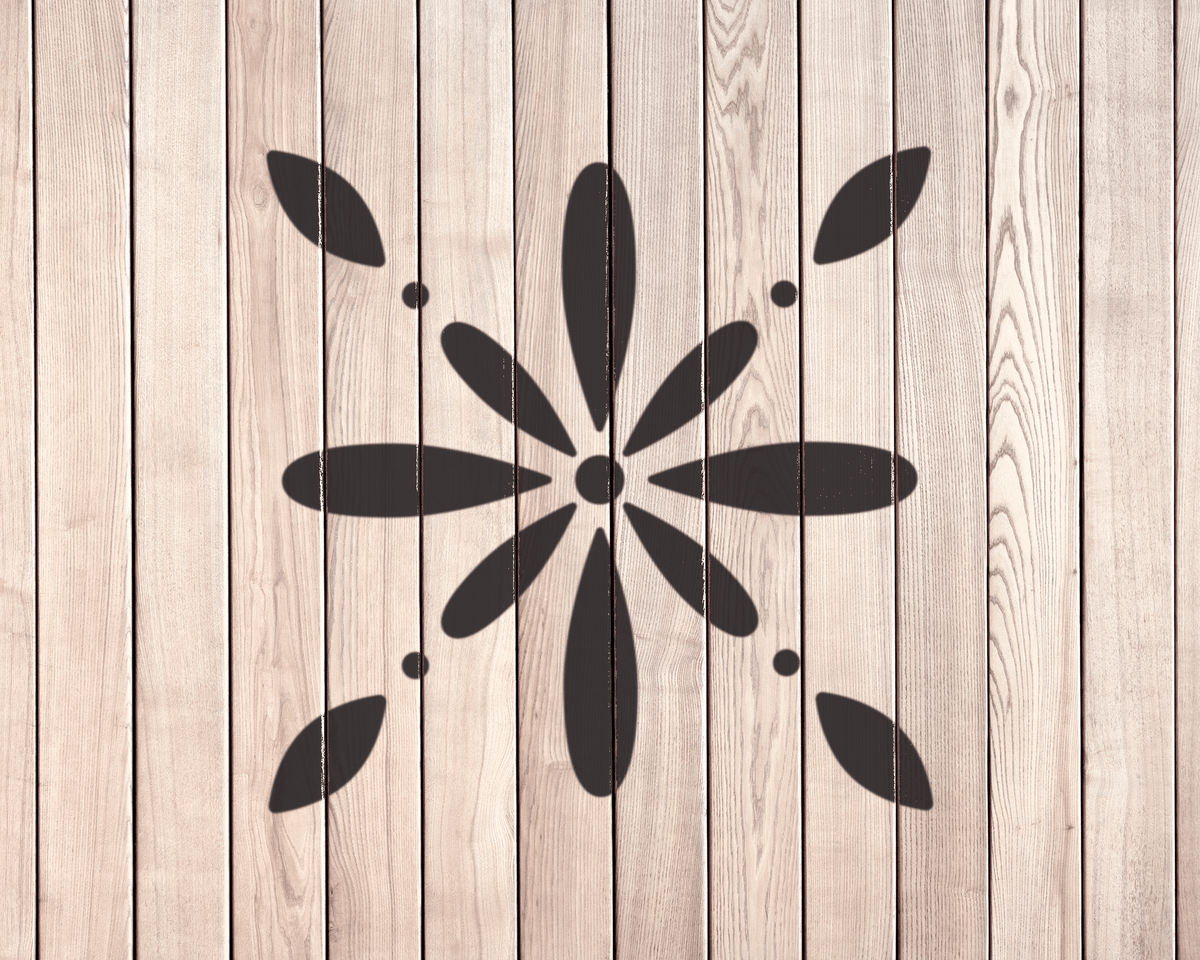 a wooden wall with a black flower-like design in the center.