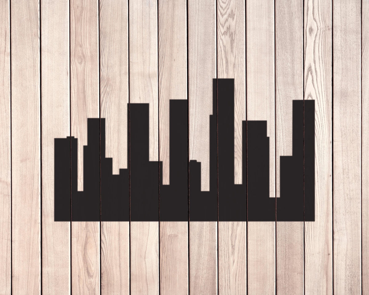A silhouette of a city skyline is displayed against a wooden background.