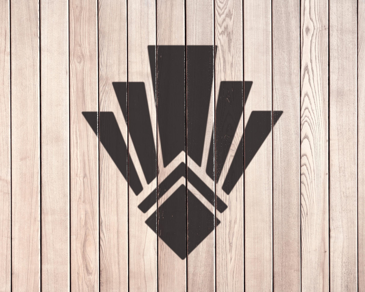 a wooden wall with a stylized black geometric design in the center.